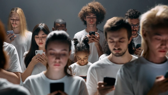 A crowd of people with white shirts facing the viewer. Everyone stared on their smartphone.